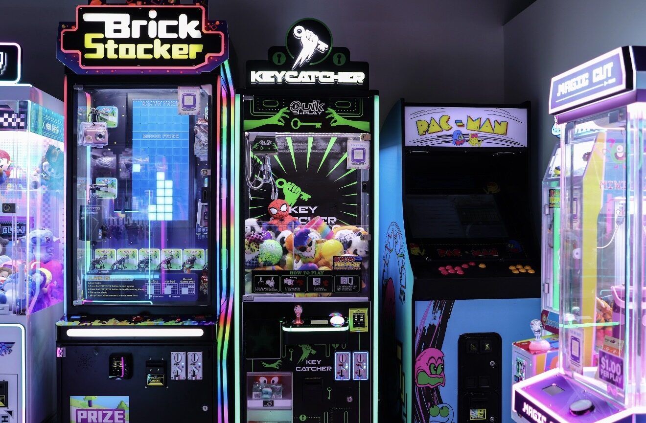 Arcade corner inside the restaurant — Brick Stocker, Key Catcher, Pac-Man, and a claw machine