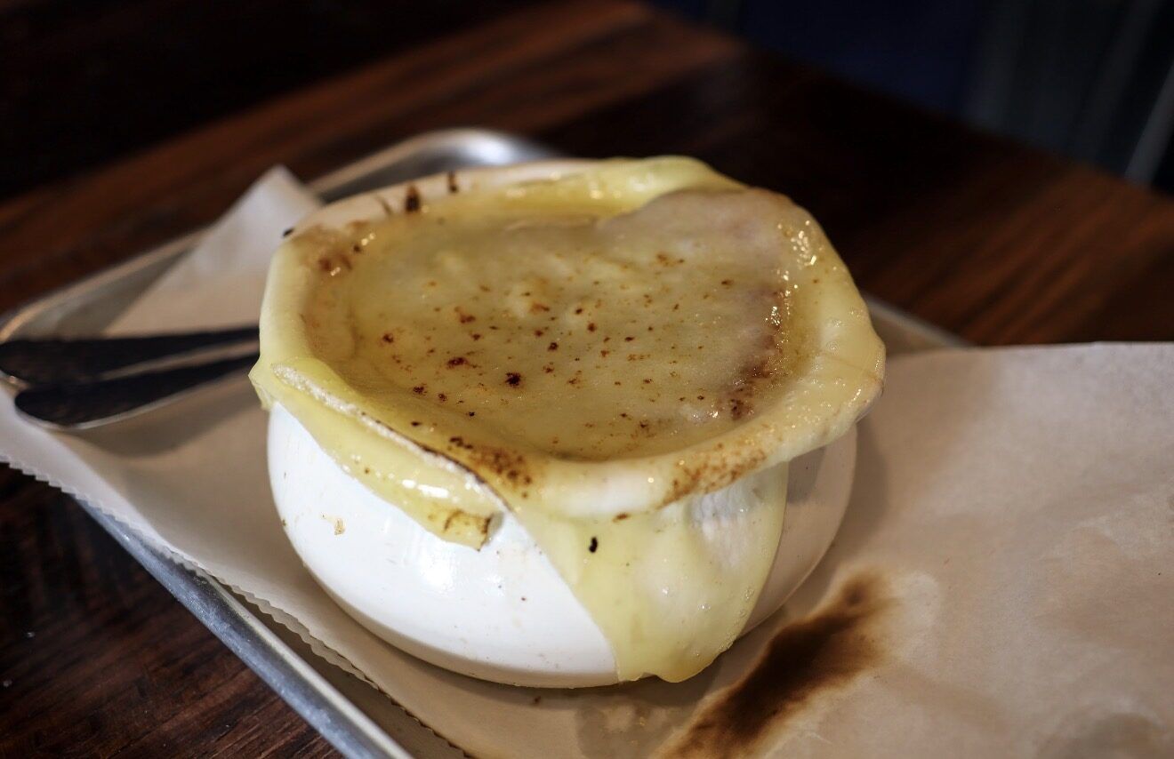 French onion soup with a broiled cheese cap spilling over the crock